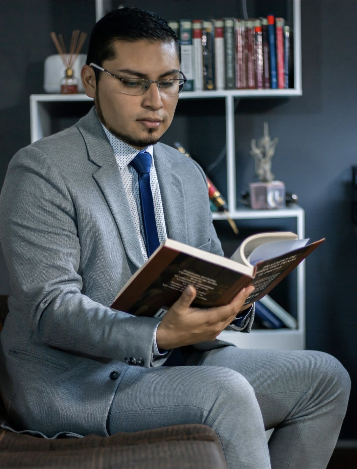 Abogado Daniel Guerra revisando un libro jurídico en su despacho en Imbabura